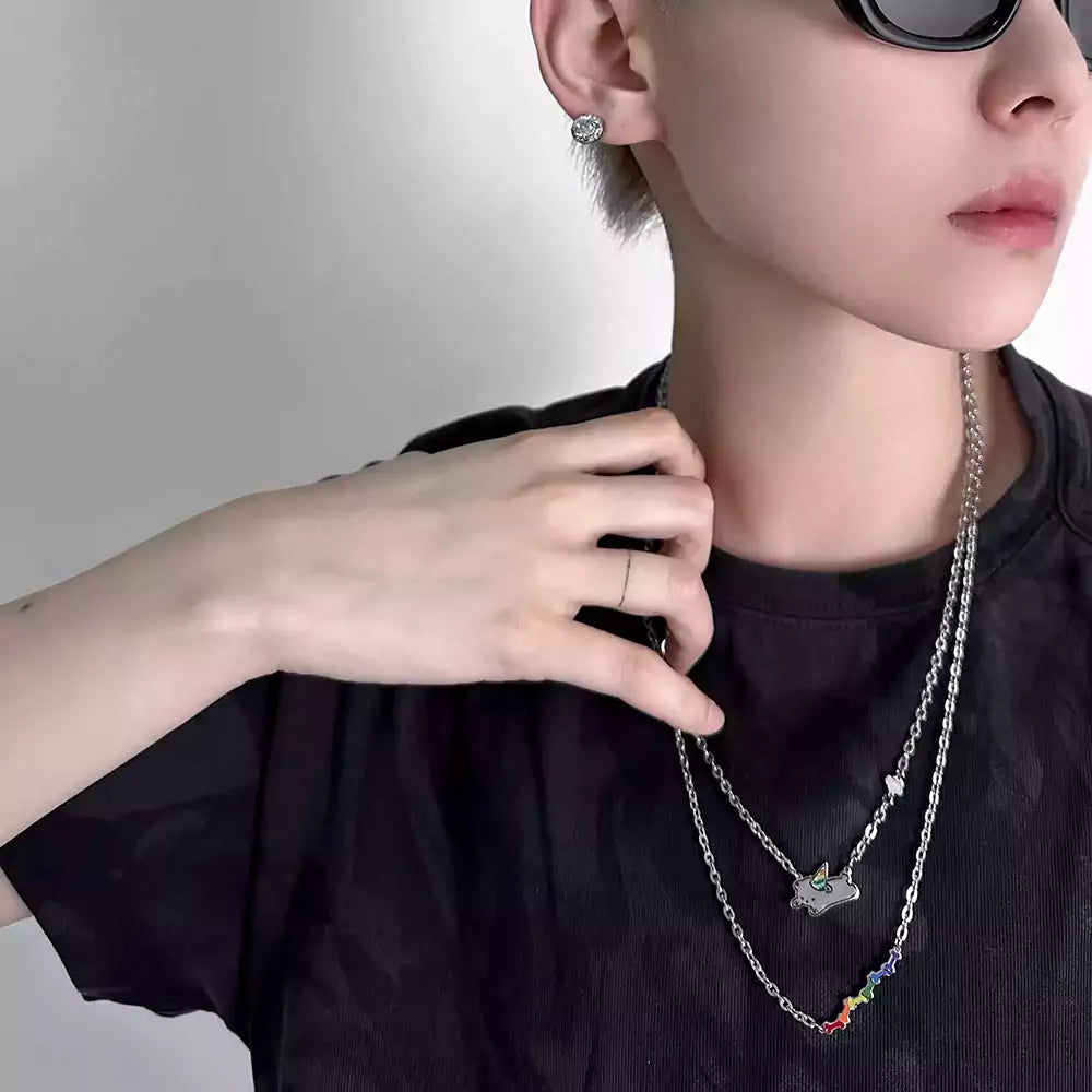 Person wearing a black shirt with layered necklaces and sunglasses 