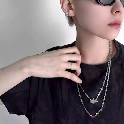 Person wearing a black shirt with layered necklaces and sunglasses 